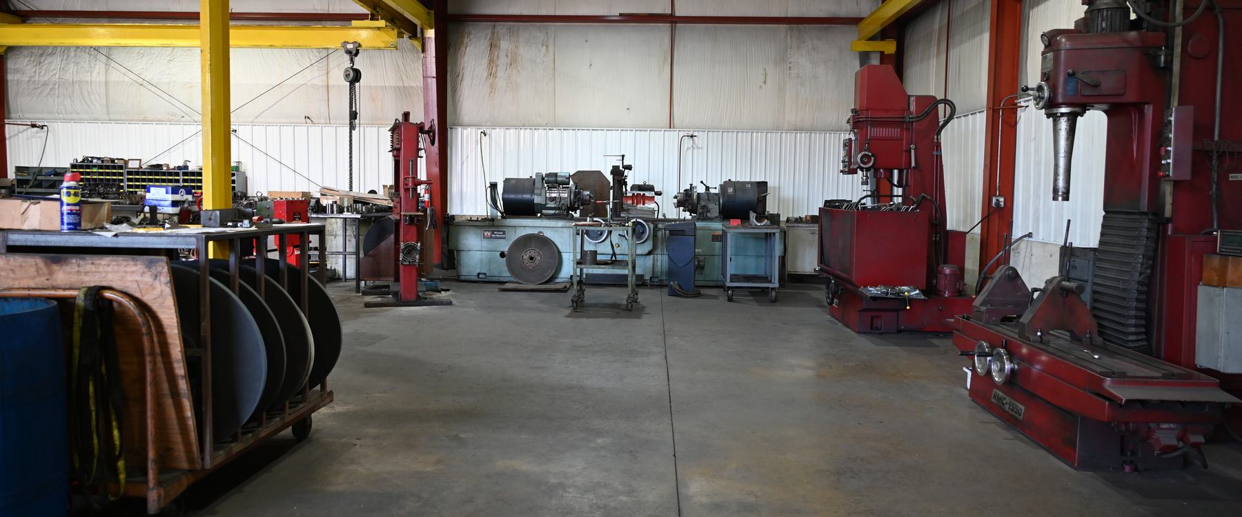 Inside PDM's engine machine shop: machining equipment along the wall, workbenches and a parts cart.