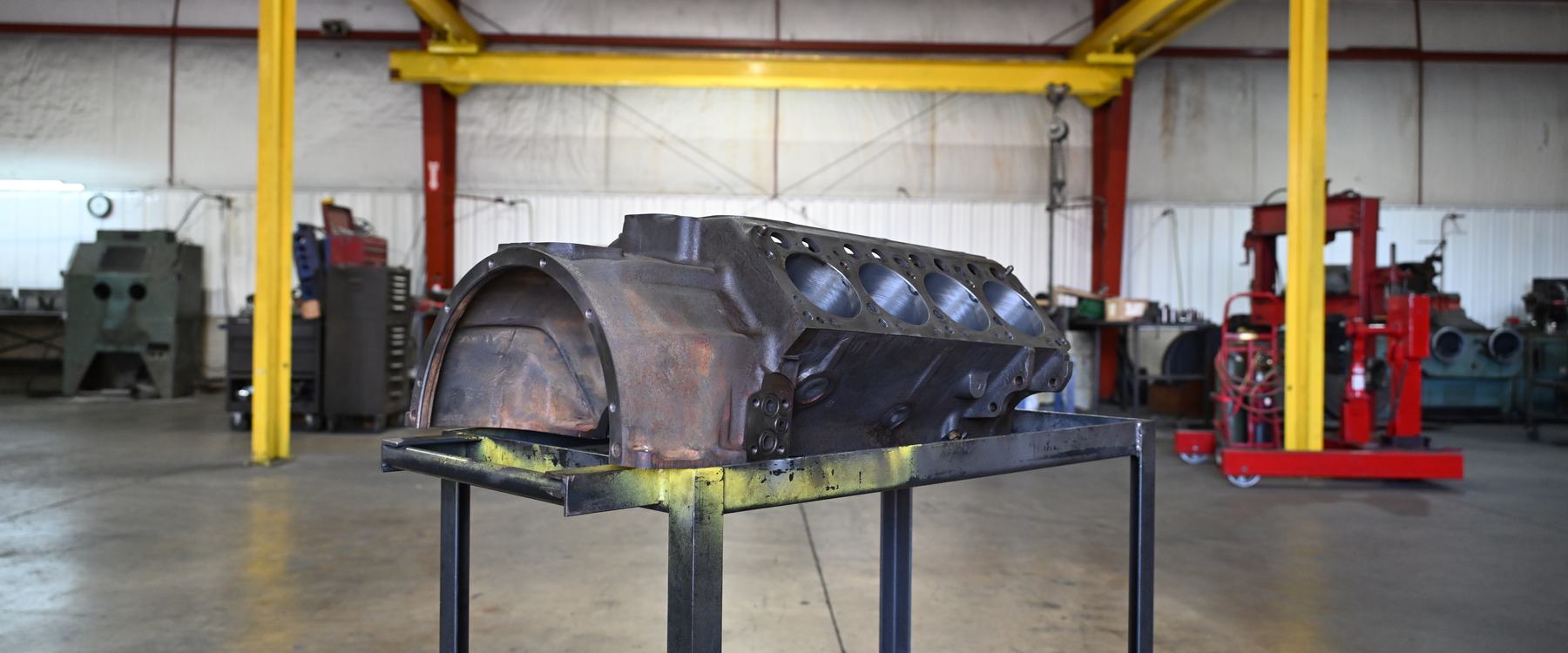 A bare V8 engine block on a steel cart on the open floor of PDM's machine shop in Sidney, Ohio.