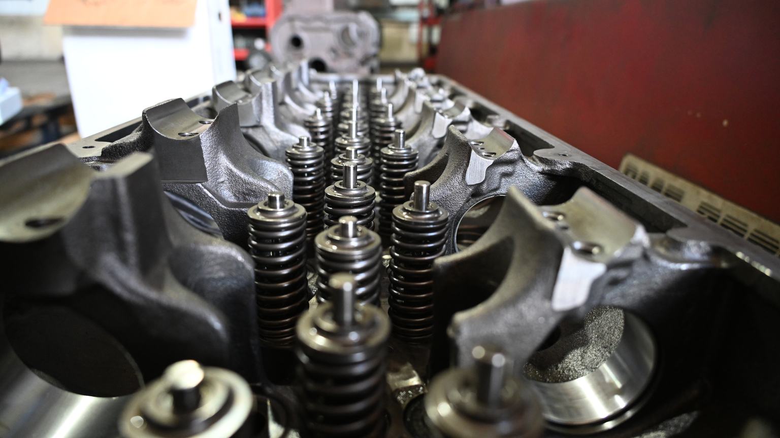 An assembled cylinder head seen low along the deck, showing rows of valve springs, retainers and valve stems.